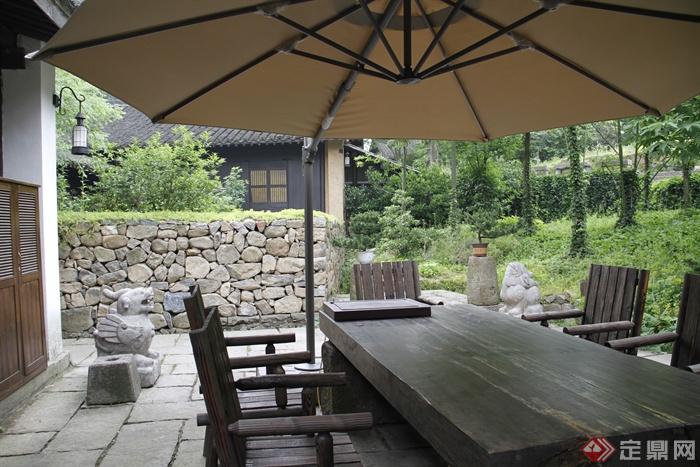 木桌椅,阳伞,石雕塑,石墙,矮墙,景观树,住宅建筑,村庄景观